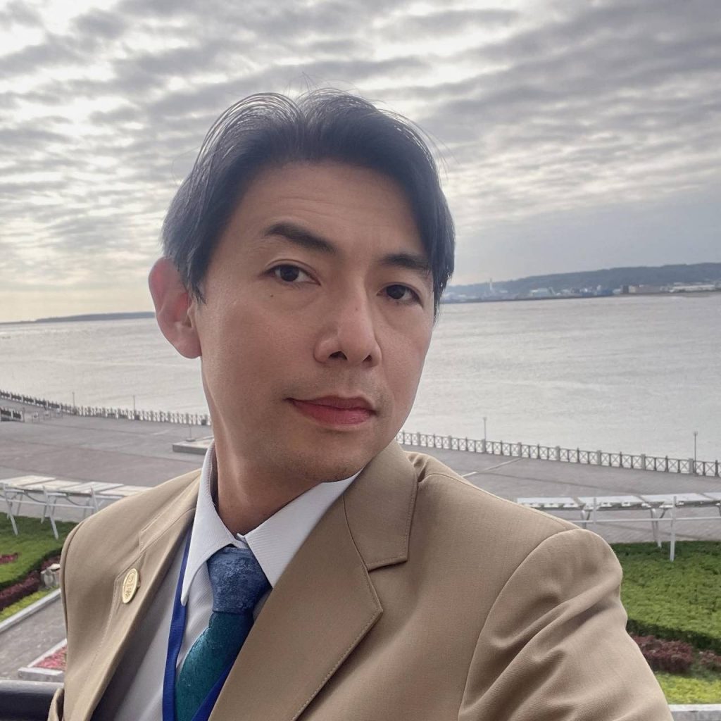 李國禎於水岸自拍，身著淺棕色西裝