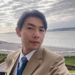 李國禎於水岸自拍，身著淺棕色西裝